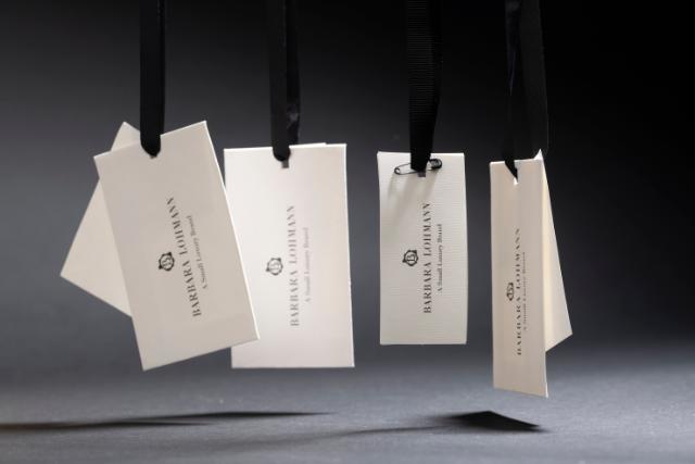 Five Hangtags in white hanging in black strings